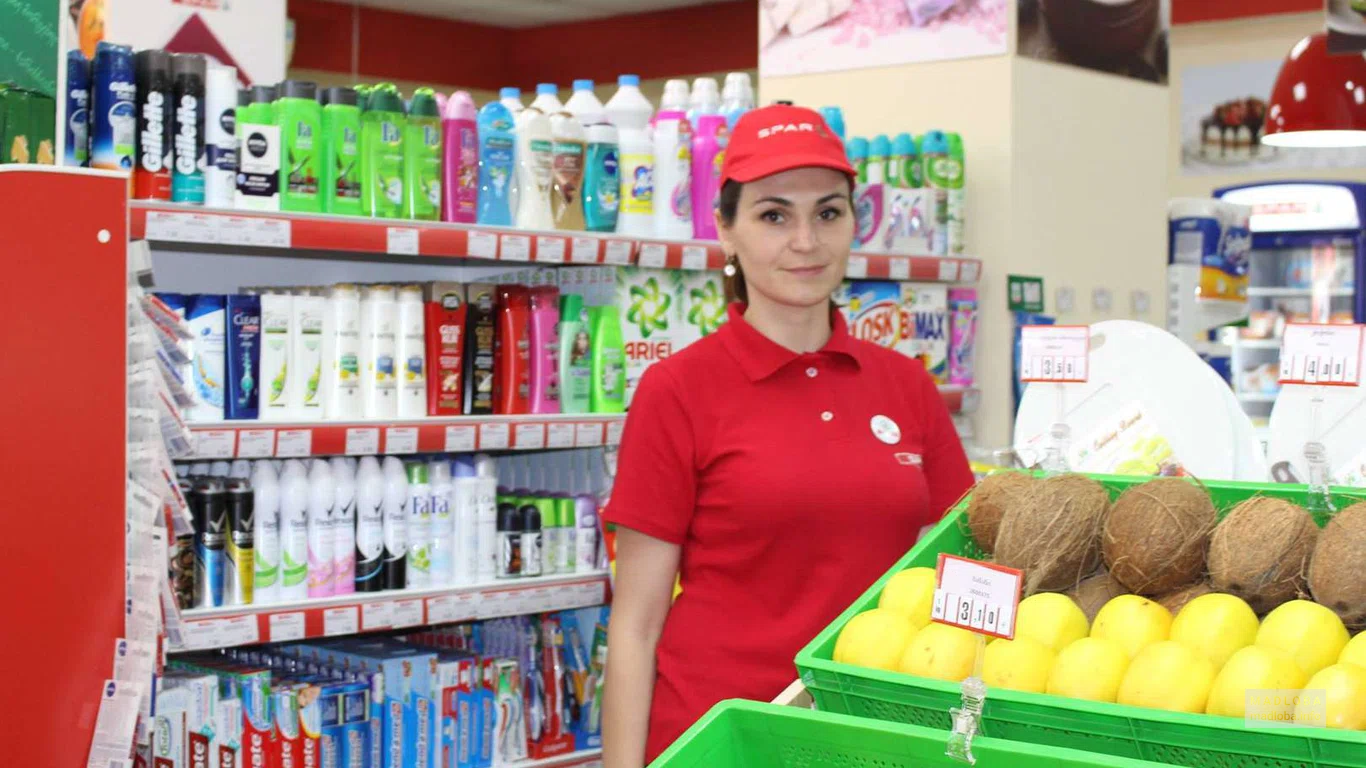 Поставщик продуктов и ритейловая сеть "Spar Georgia" сотрудник на фоне продуктов