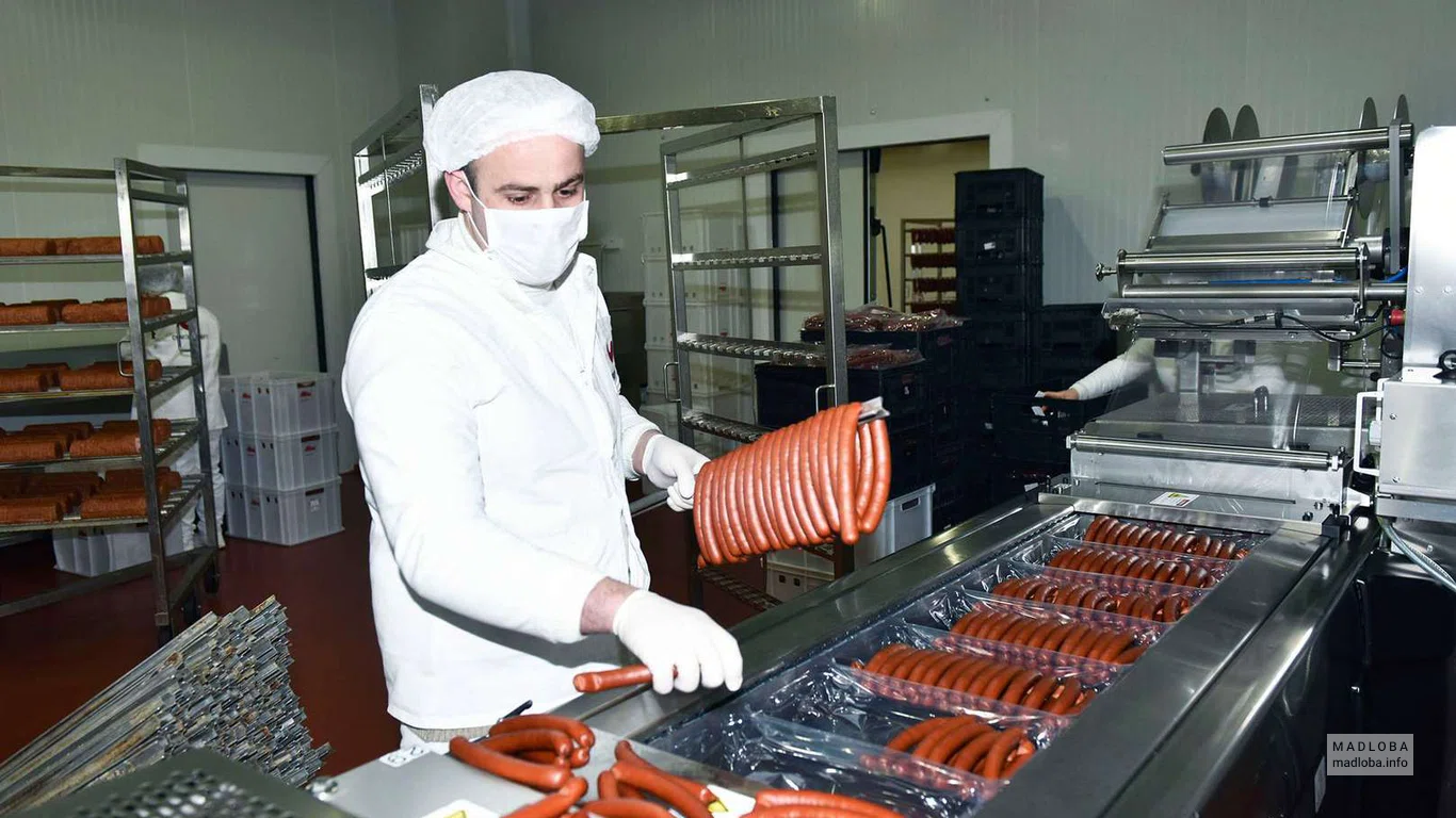 Сотрудник "Lider Food" разлаживает колбаски