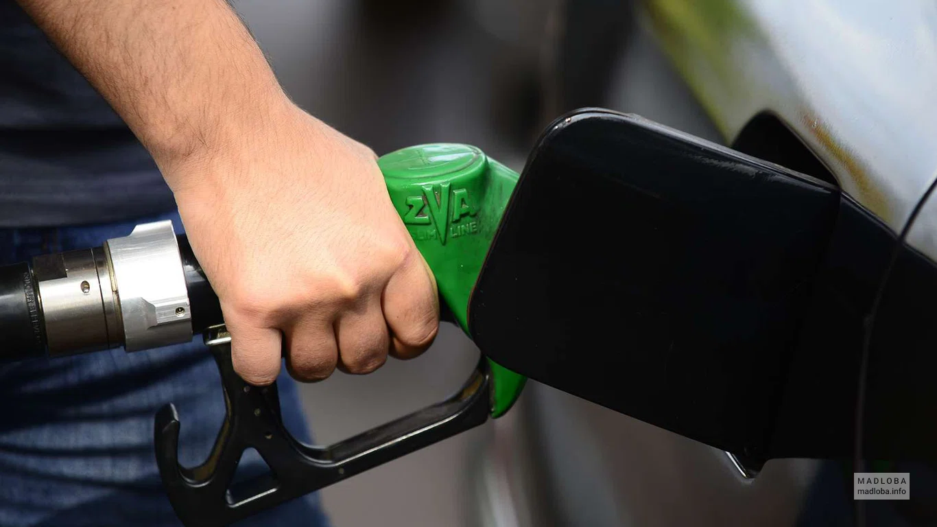 Заправка "Rompetrol Georgia" сотрудник заправляет машину