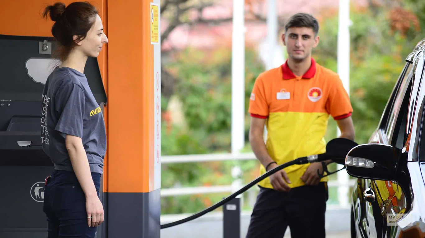 Заправка "Rompetrol Georgia" сотрудник заправляет машину