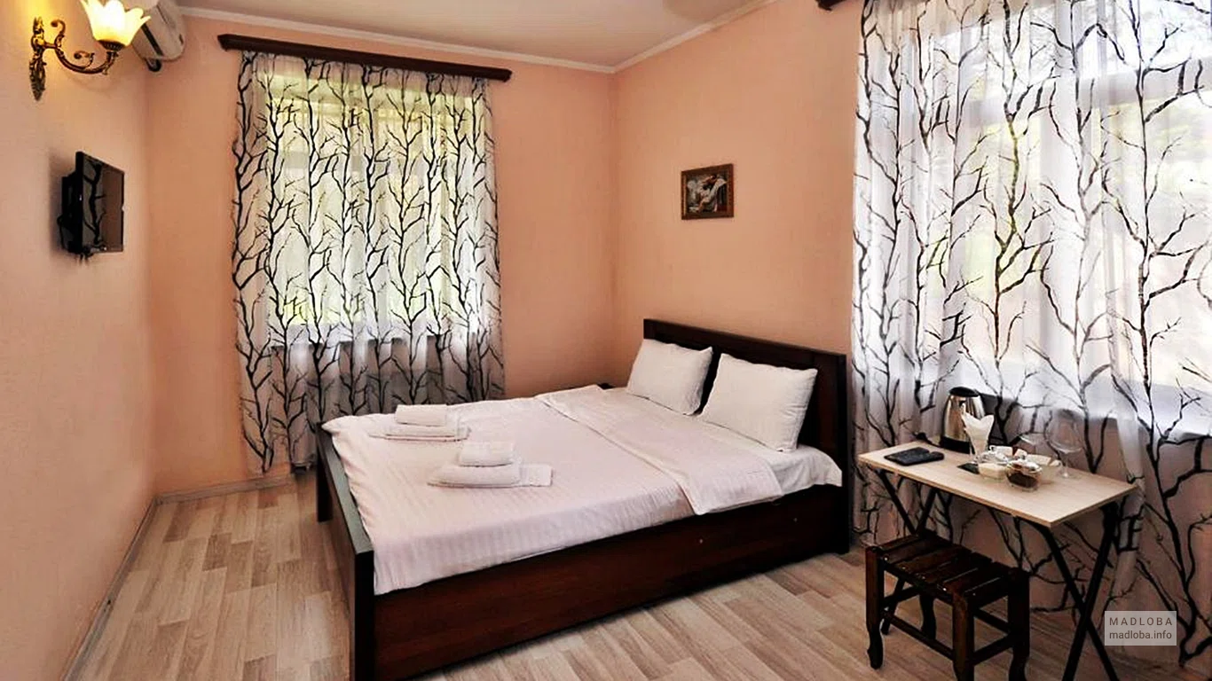 Кровать в номере гостиницы Meidan INN