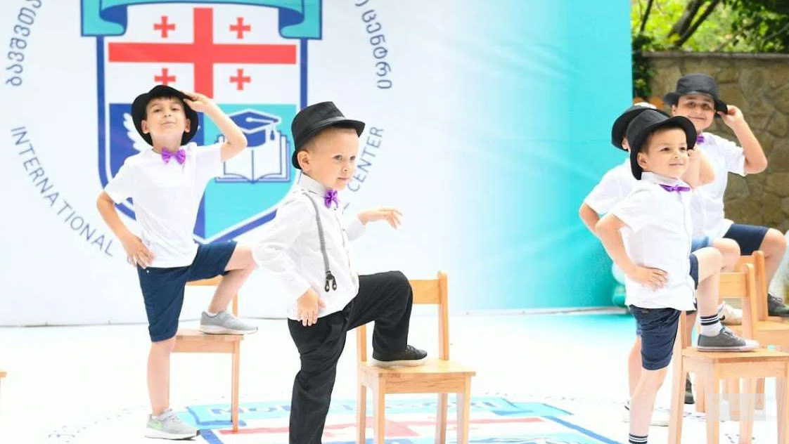 Дети танцуют на празднике в частном детском саду Montessori