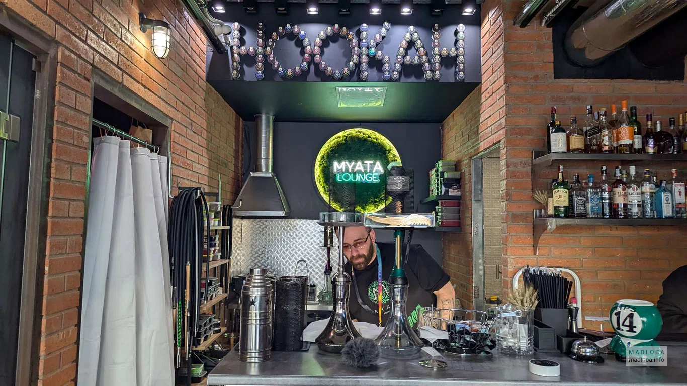 сотрудник заправляет кальян в кальянной Myata Lounge | Tbilisi