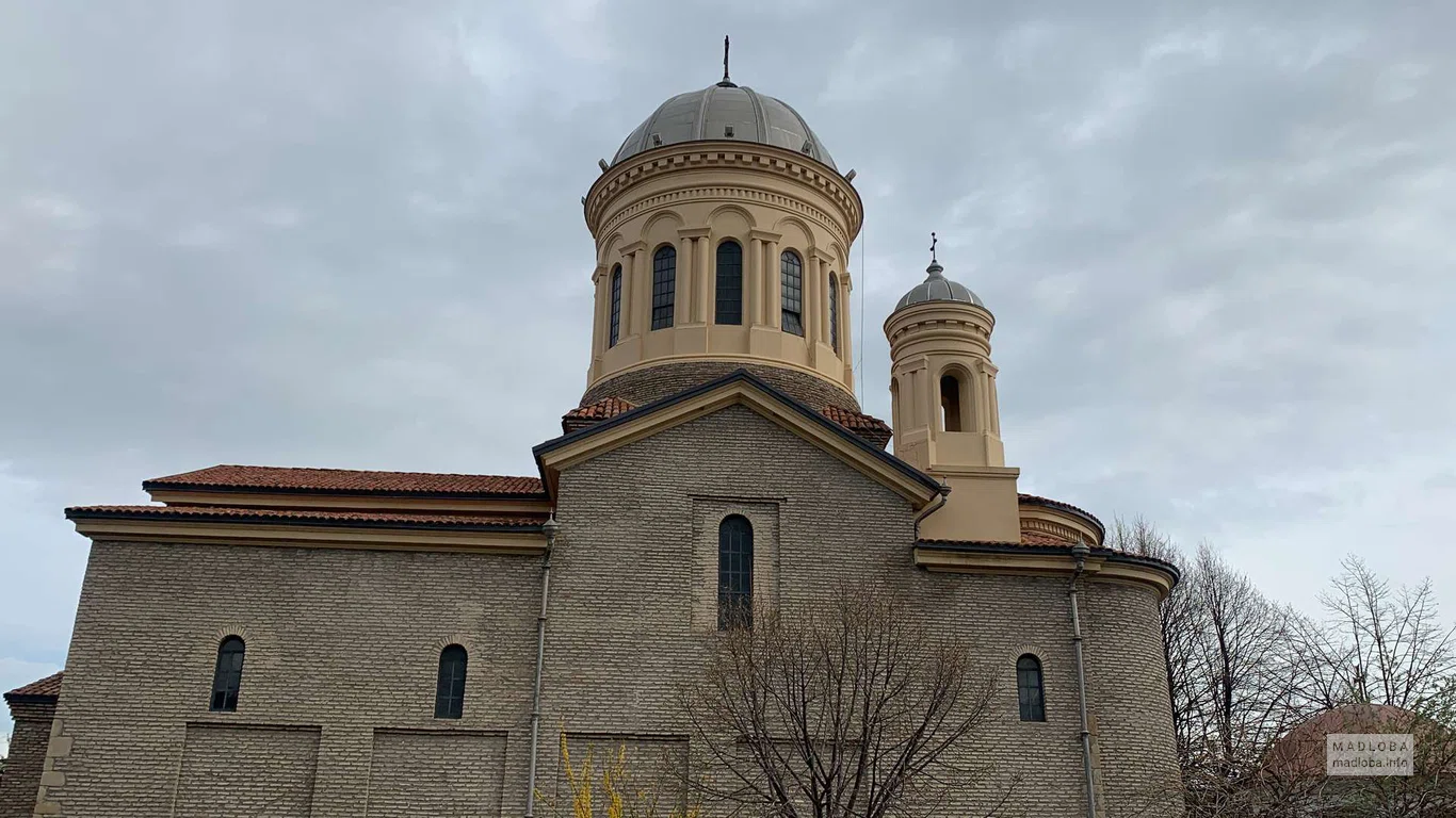 Основное здание собора с акцентом на его центральный купол, величественно возвышающийся над зеленью