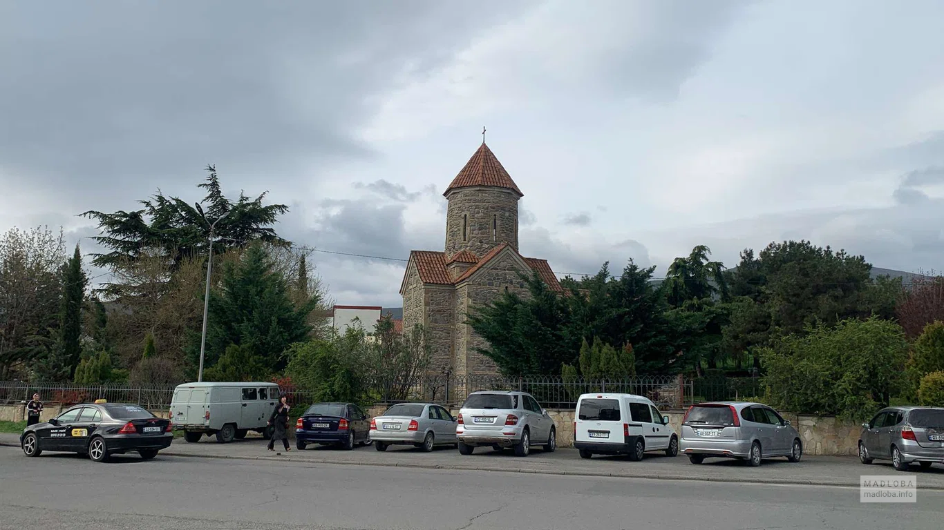Детальный вид фасада часовни с её красной черепичной крышей и каменными стенами