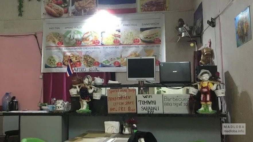 Вывеска над барной стойкой с меню в кафе Tom Yum