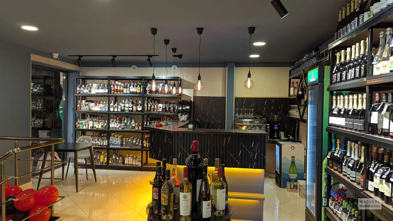 Барная стойка и полки с алкоголем в Wine Palette