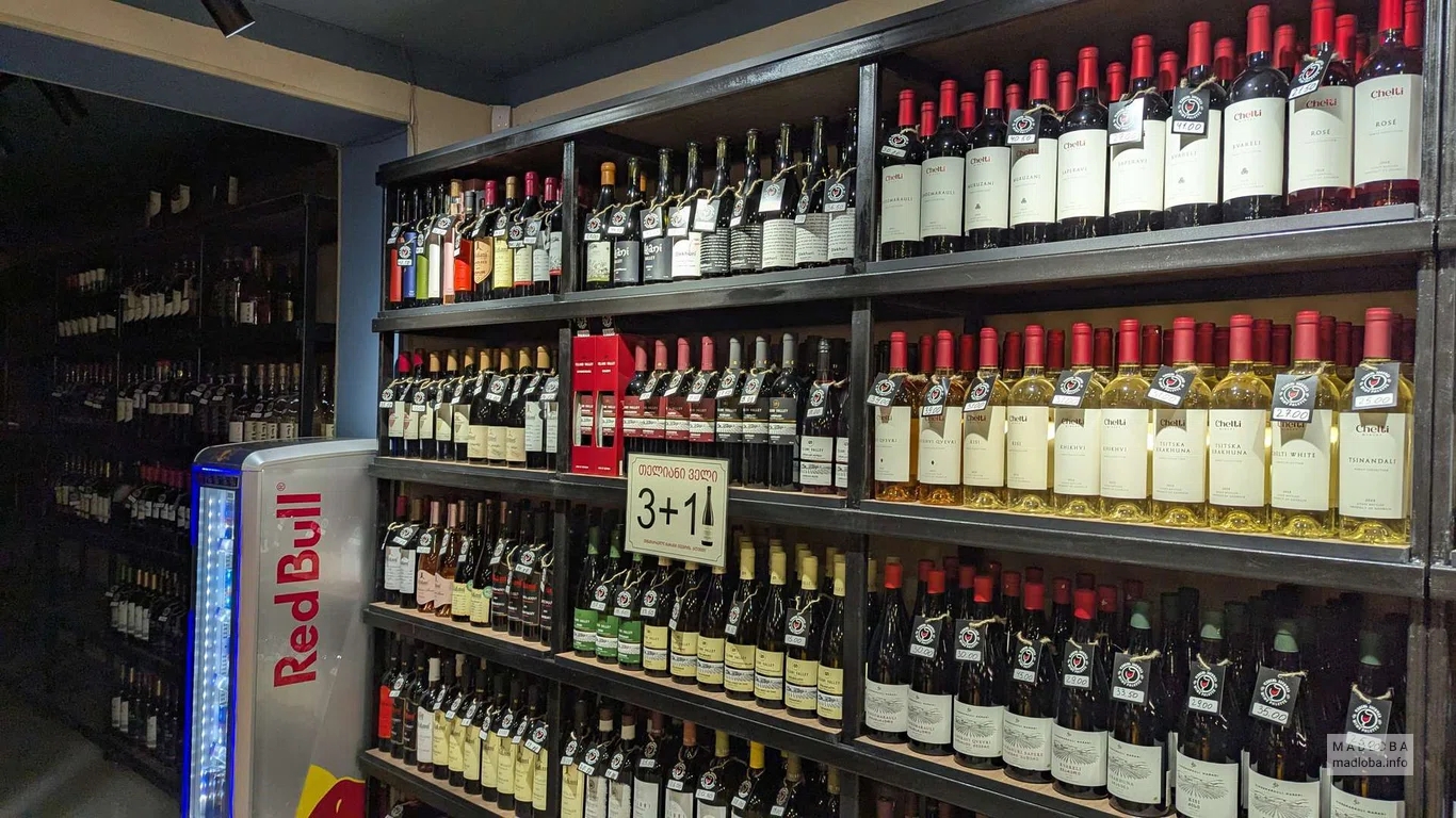 Полки с бутылками вина и акцией в винном баре Wine Palette