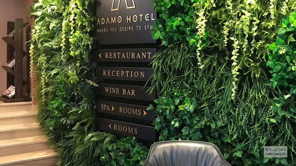 Логотип Adamo Hotel в холле