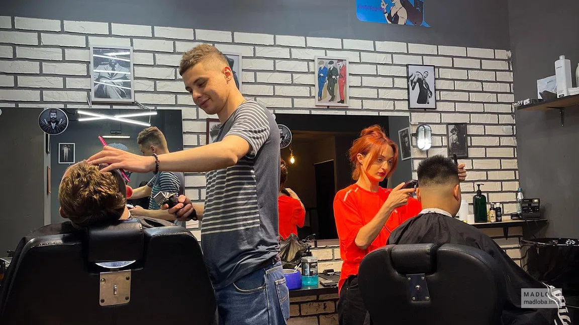 мастер делает стрижку в Clippers Barbershop