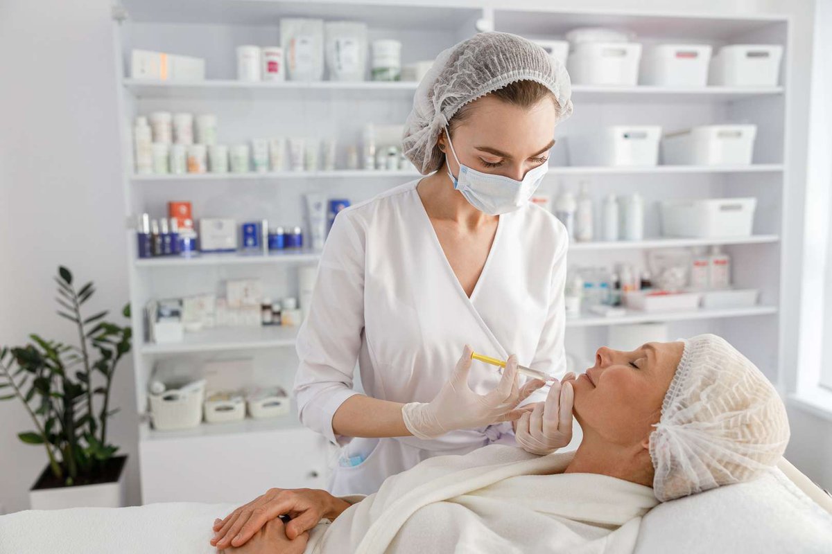 A cosmetologist performs an injection procedure