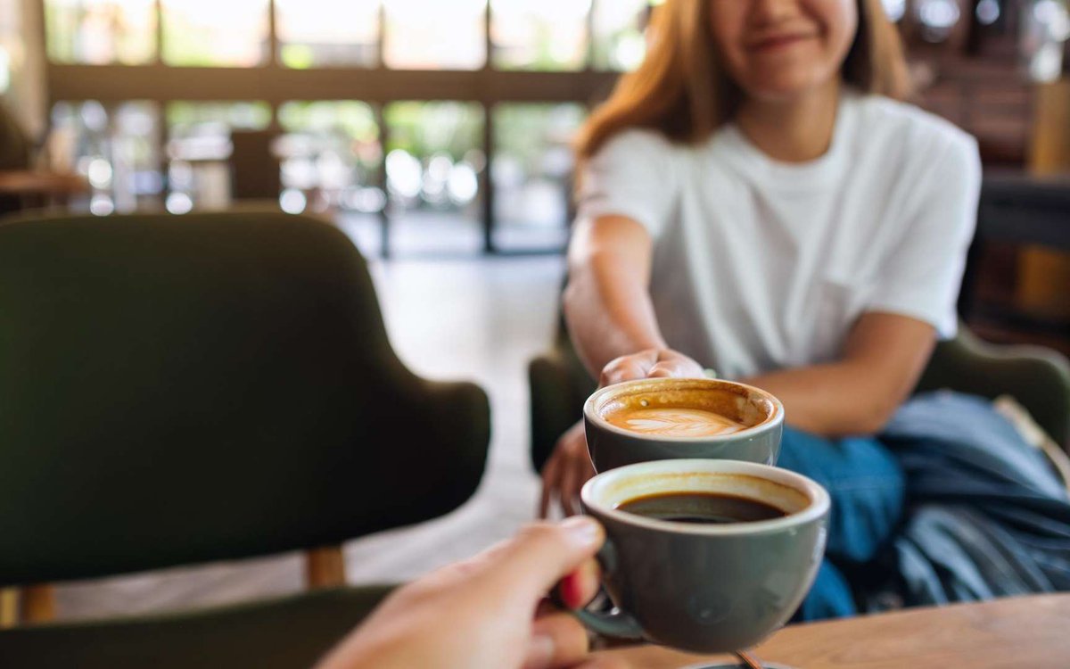 A woman and a man drink coffee in a coffee shop