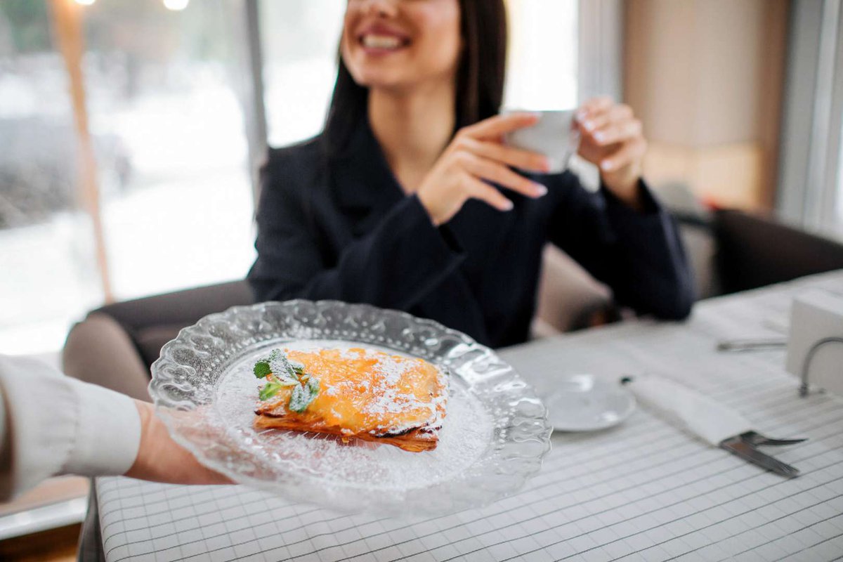A smiling girl with an ordered breakfast