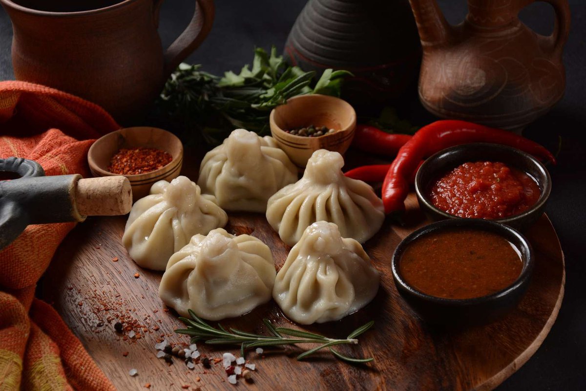 Georgian khinkali surrounded by sauce and wine