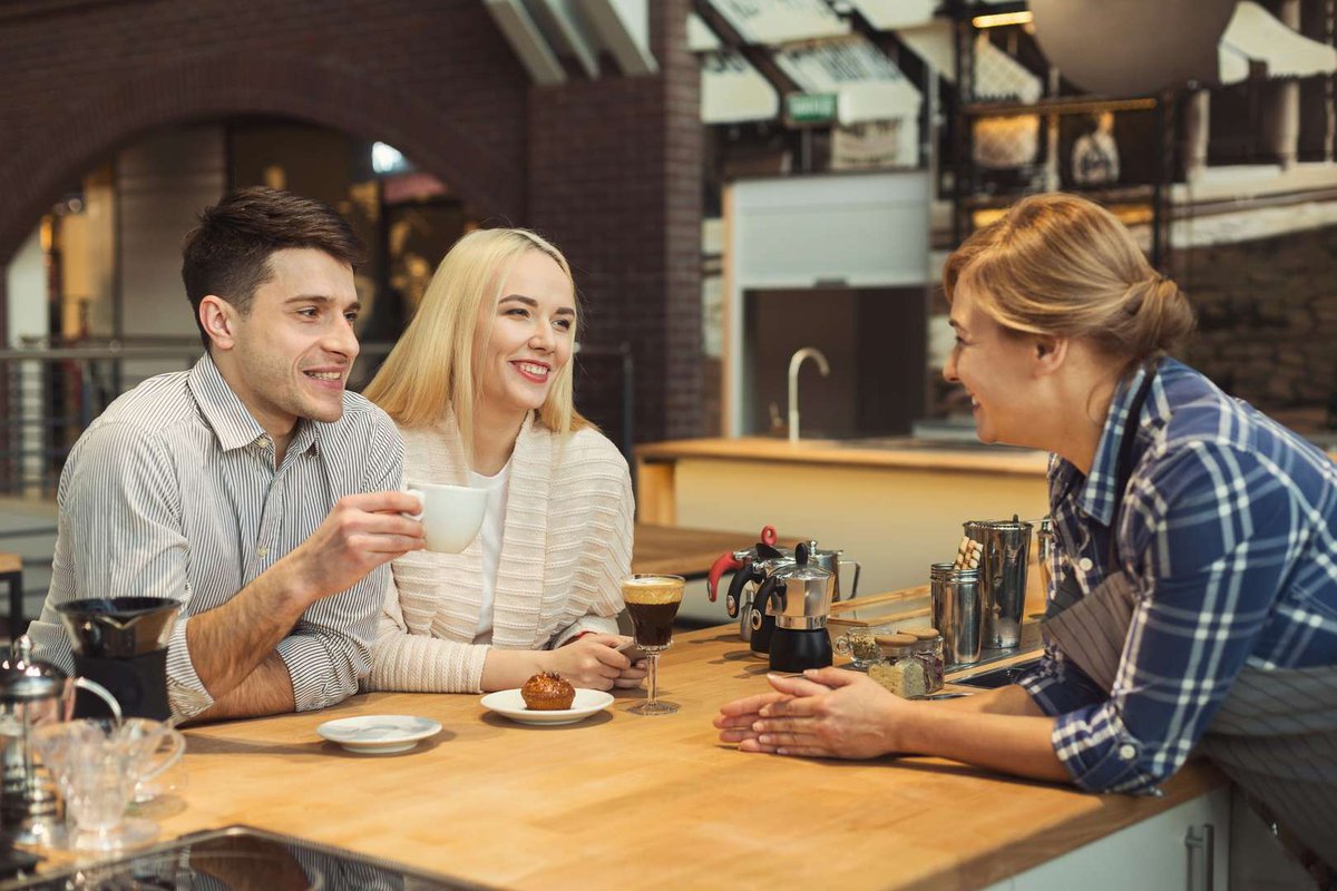 The barista communicates with the guests of the coffee shop