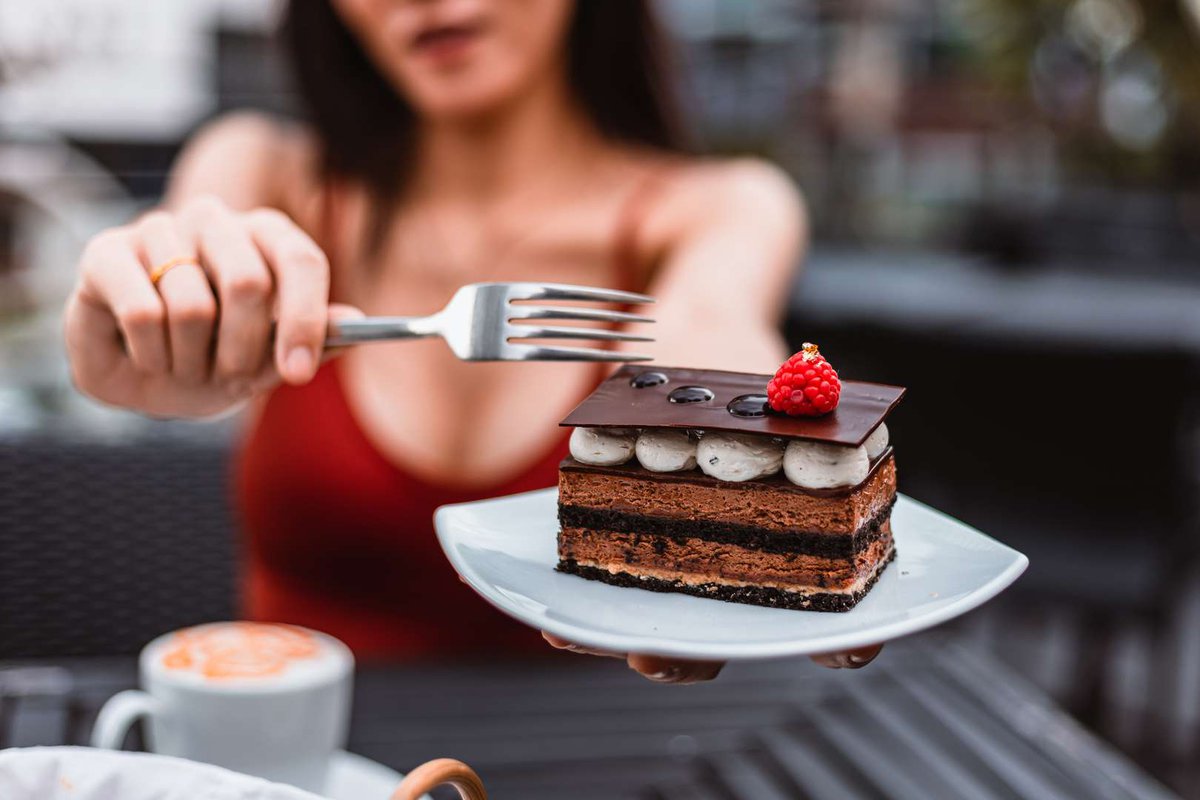 The girl holds a plate with a cake