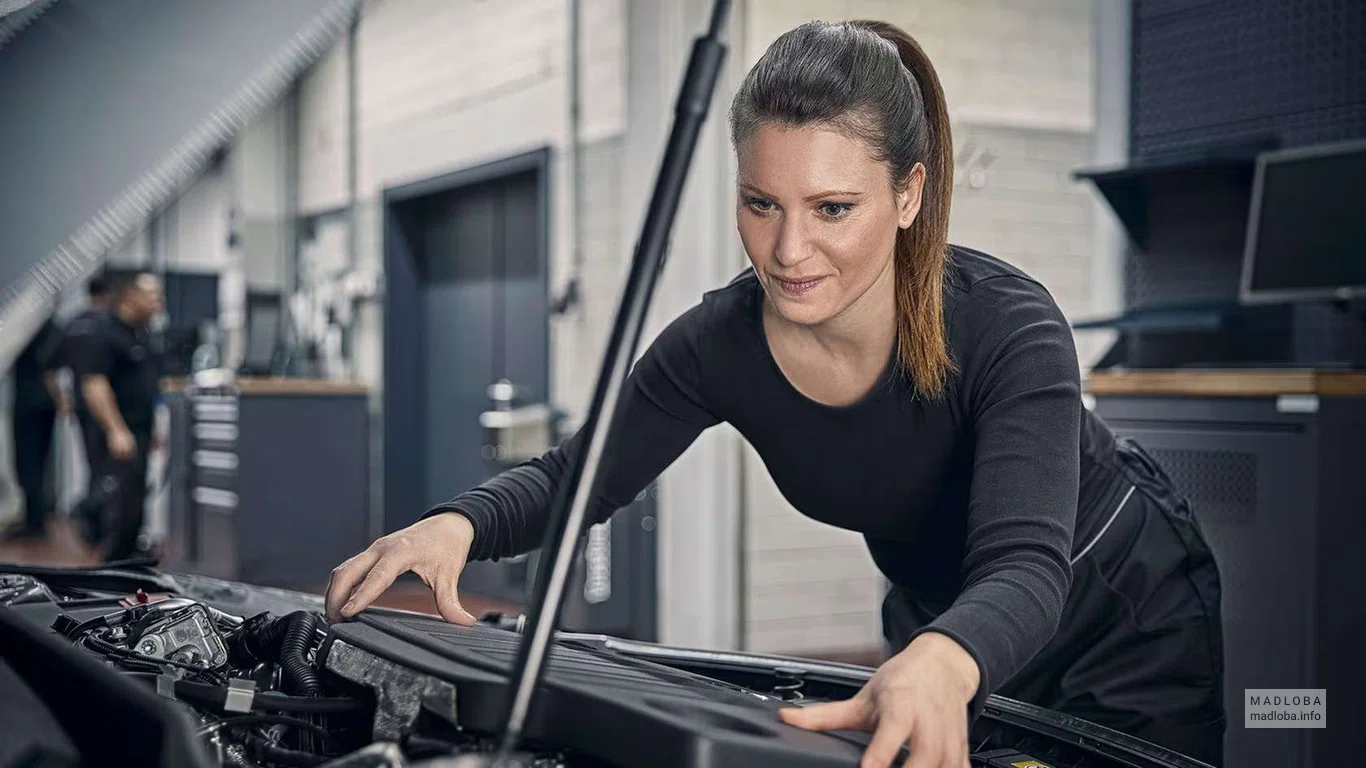 Сотрудница осматривает автомобиль в сервис-центре автообслуживания "Aka Mercedes-Benz Georgia"