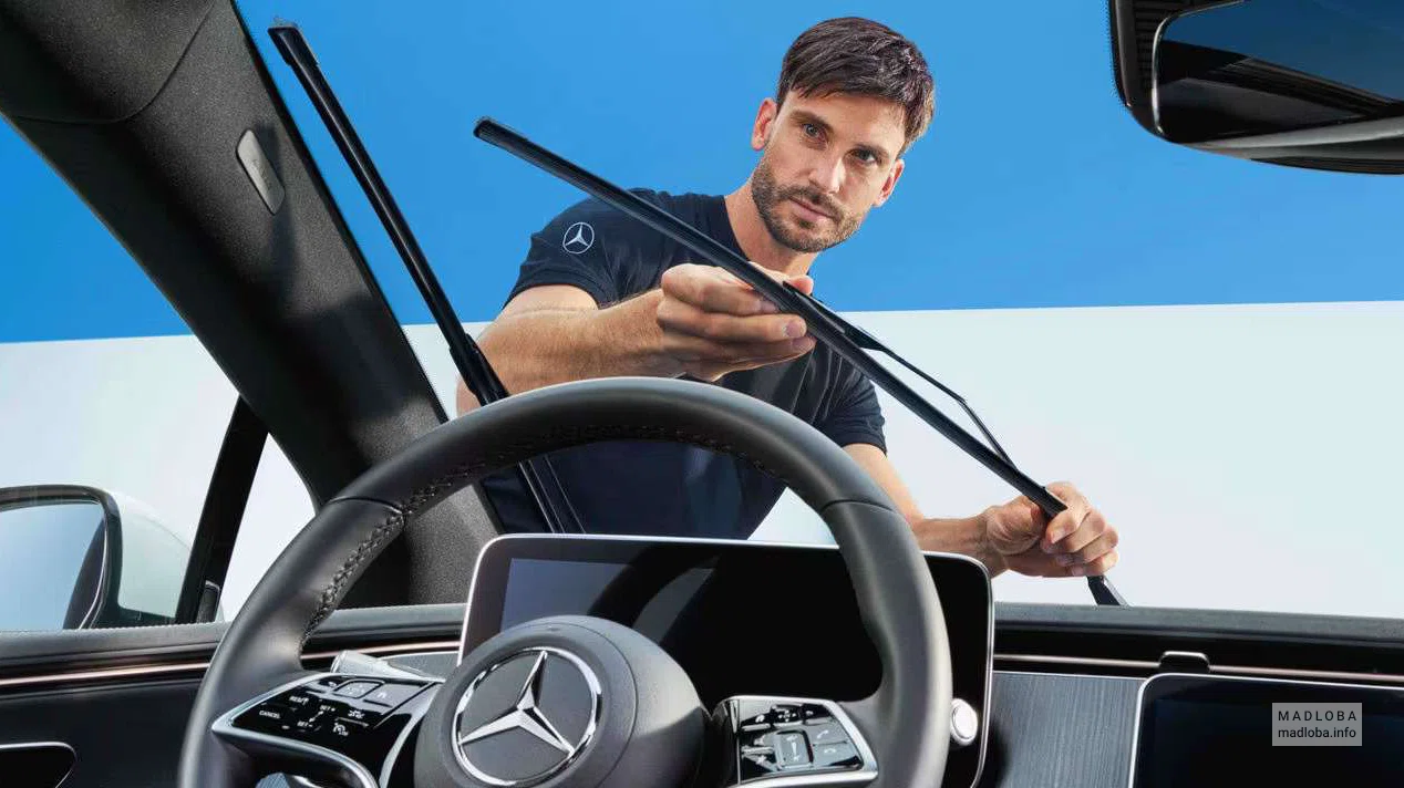Сотрудник осматривает автомобиль в сервис-центре автообслуживания "Aka Mercedes-Benz Georgia"