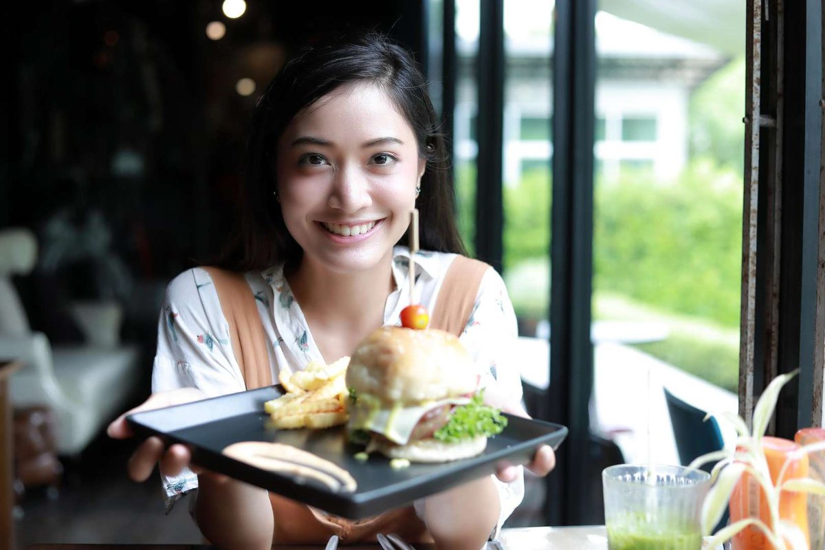 A girl with a non-standard restaurant burger