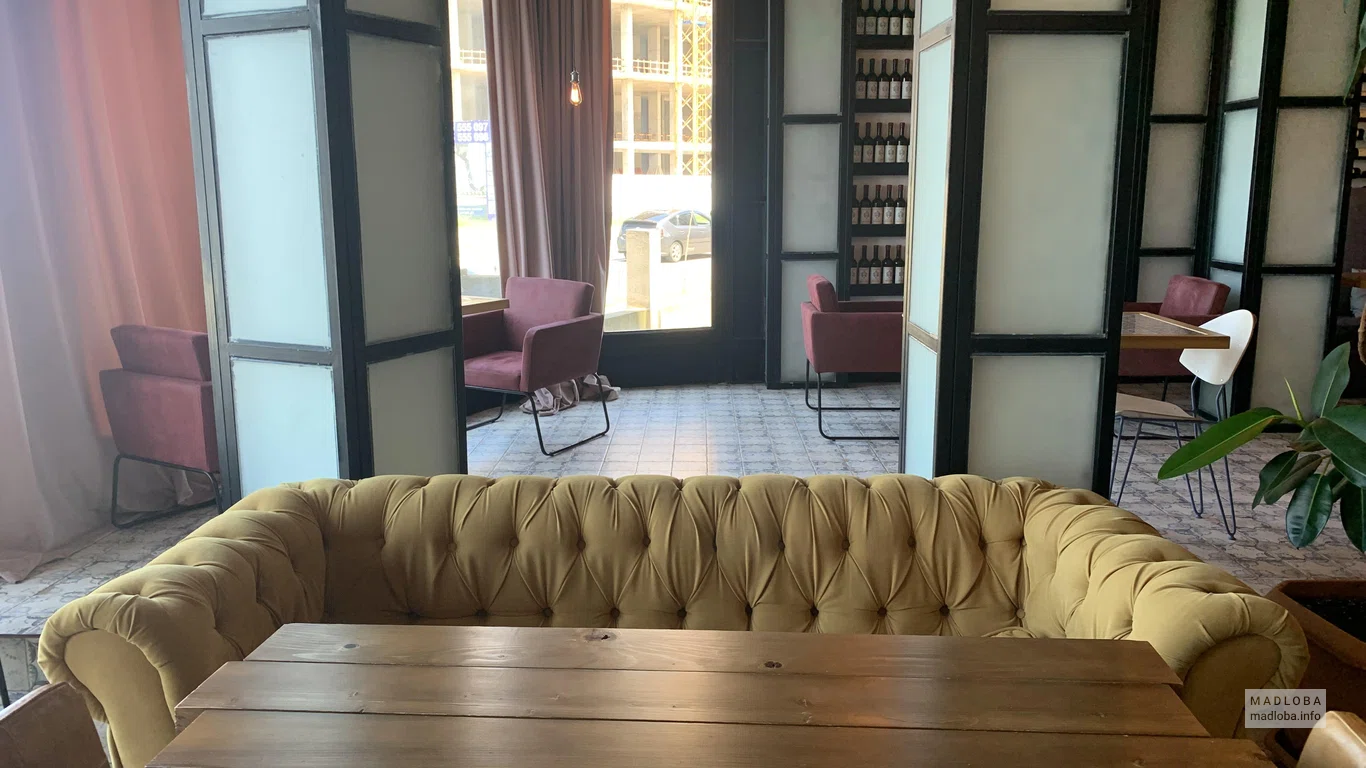Деревянный стол с диваном в ресторане RoofTop Pool Hotel Batumi
