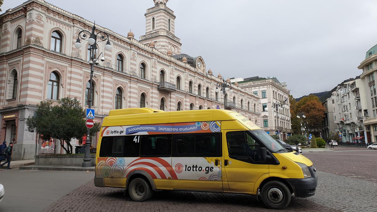 Маршрутка едет по  площади Свободы в центре Тбилиси.