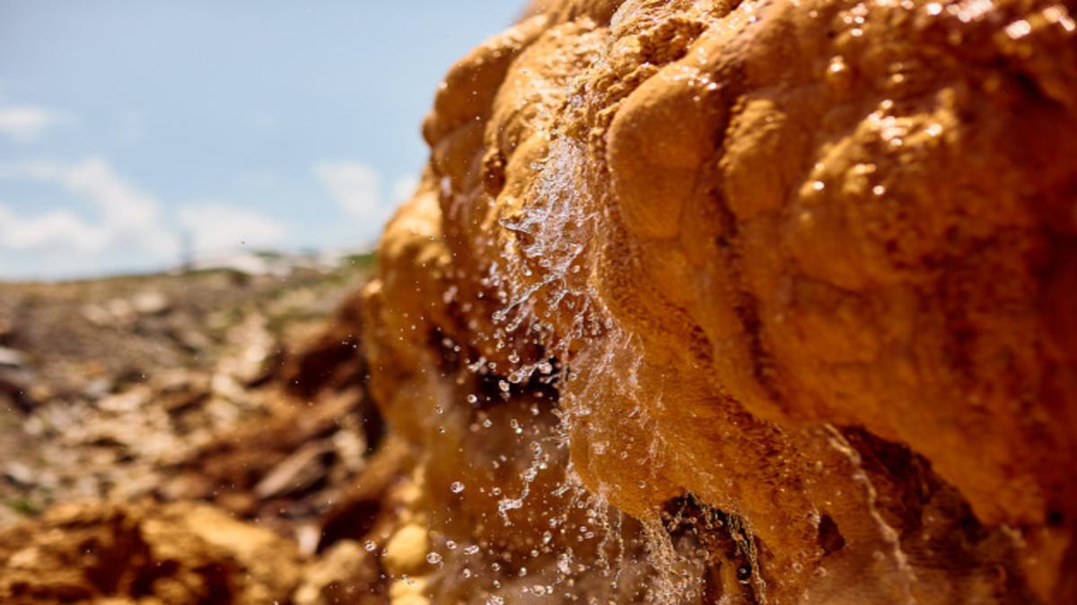 Чистая минеральная вода стекает с камня