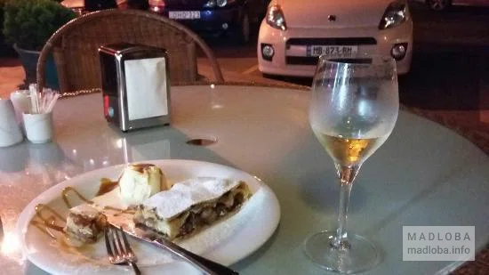 Десерт с бокалом вина в кафе Ла -- Терасса