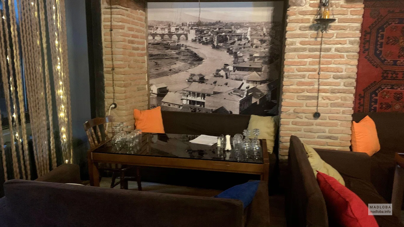 Столик на фоне черно-белой картины в Cafe Top shelf lounge