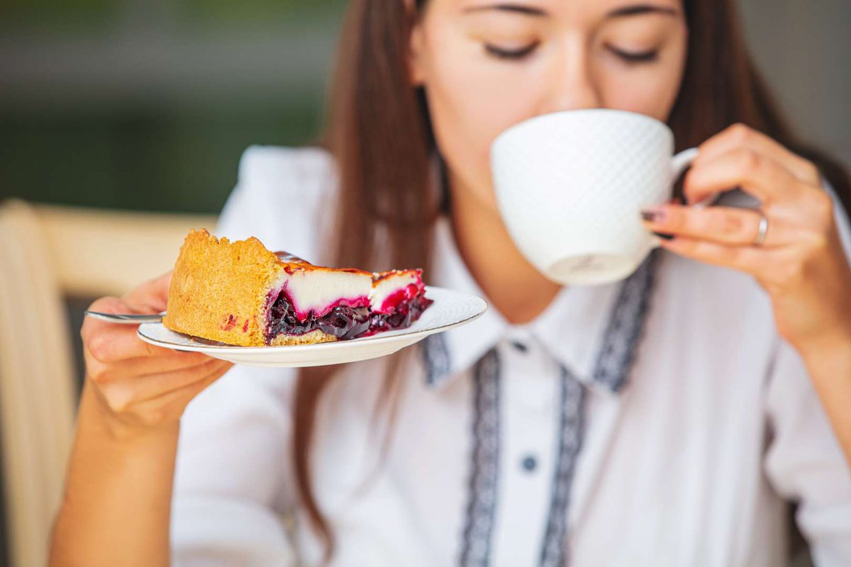 The girl enjoys a delicious dessert and tea