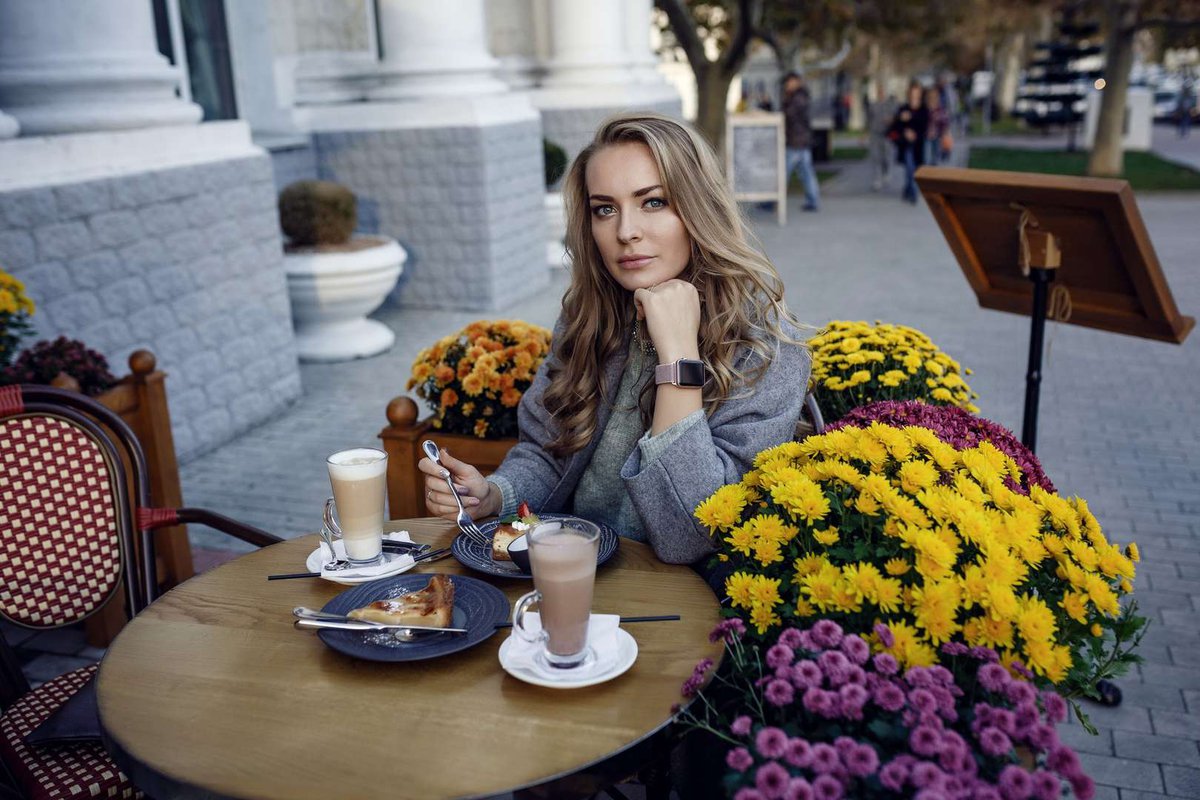 The girl is having breakfast outside the cafe