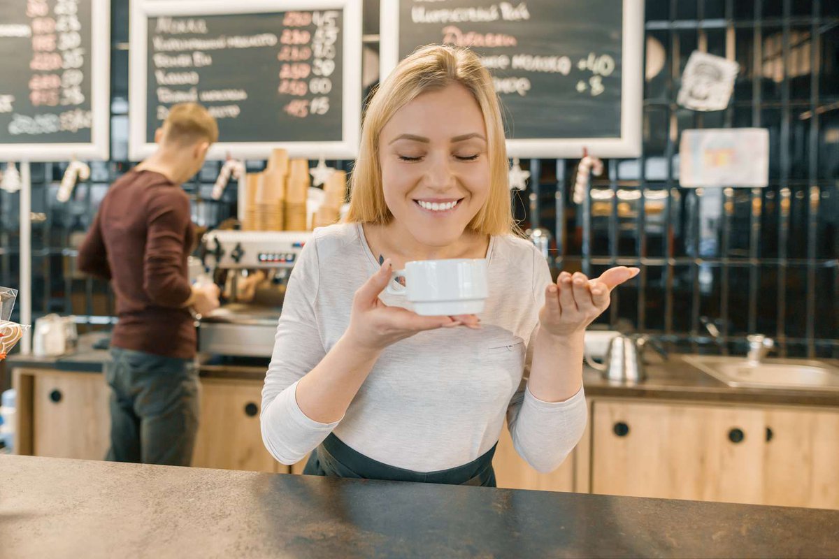 The girl enjoys the aroma of coffee