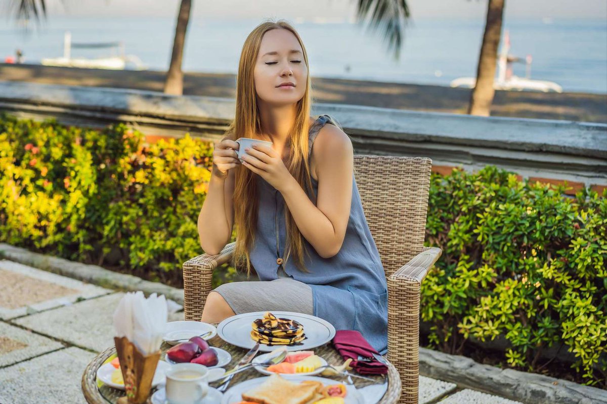 A girl enjoys dessert outside a pastry shop